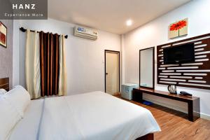 1 dormitorio con 1 cama blanca y TV en HANZ SEN Hotel, en Ho Chi Minh