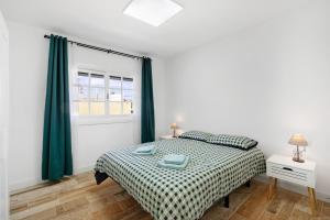 a white bedroom with a bed and a window at La Carpinteria in Tacoronte