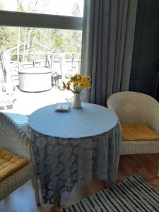 a table and chairs with a vase of flowers on it at Mellene 1 bedroom house in nature & hot tube in Turaida