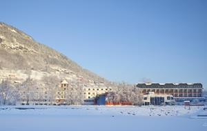 un edificio en la nieve junto a una montaña en Park Hotel Vossevangen, en Vossevangen