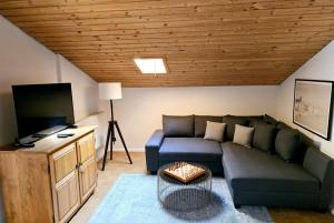 een woonkamer met een bank en een tv bij Chalet Anna in Unterwössen