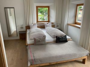 two twin beds in a room with a mirror at Landgasthof Dorfstadl in Kössen