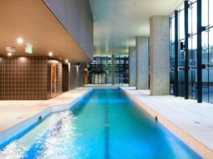 a swimming pool with blue water in a building at Spencer St Serenity Chic Urban Escape in the CBD in Melbourne