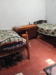 Zimmer mit 2 Betten und einem Schreibtisch. in der Unterkunft Green Fields in Colovale