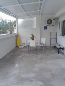 Habitación blanca con mesa y sillas. en Apartman Miro, en Cavtat