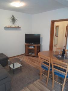 a living room with a table and a flat screen tv at Apartman Miro in Cavtat