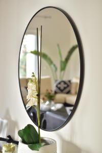 un espejo en una mesa con una flor en un jarrón en Elia Seaside Villa, Amazing 2-Story Eco Pool House! en Kissamos