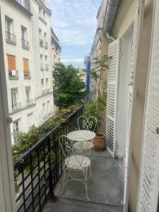 a balcony with a table and chairs and buildings at Aux Terrasses de la Lune in Paris