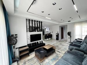 uma sala de estar com um sofá e uma televisão em Twin house 4 master Bedrooms premium mountain view Ras Elhekma em Ras Elhekma