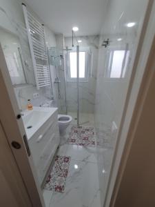a white bathroom with a shower and a toilet at Mar & Sol Spain in Empuriabrava