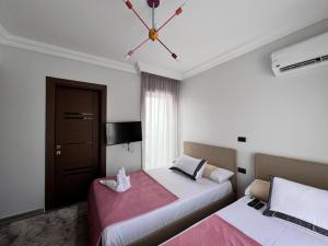 um quarto com 2 camas e um lustre em Twin house 4 master Bedrooms premium mountain view Ras Elhekma em Ras Elhekma