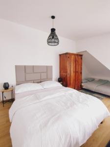 sypialnia z dużym białym łóżkiem i żyrandolem w obiekcie Attic apartment Catnip w Bratysławie