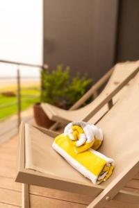 LangstrandにあるDeja Blue Beachfront Villaの黄色いタオルとベンチに座るぬいぐるみ