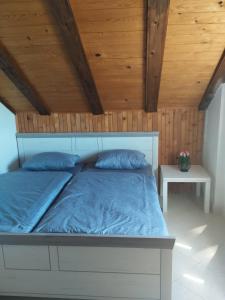ein Bett in einem Zimmer mit Holzdecke in der Unterkunft Family apartments TOMY in Punat