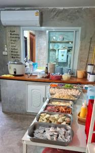 a kitchen with several trays of food on a table at Cactus Resort in Ko Larn