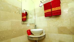 y baño con lavabo blanco y toallas rojas. en The Legian 777 en Legian