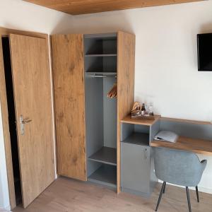 a room with a desk and a wooden closet at Landgasthof Dorfstadl in Kössen