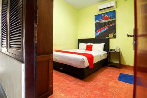 1 dormitorio con 1 cama con almohada roja en The Legian 777 en Legian