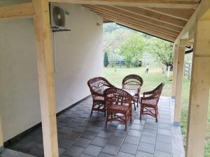 a patio with wicker chairs and a table at Apartman Quince Gradac in Valjevo