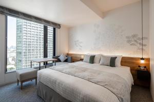 a bedroom with a large bed and a large window at Tokyu Stay Shinjuku Eastside in Tokyo