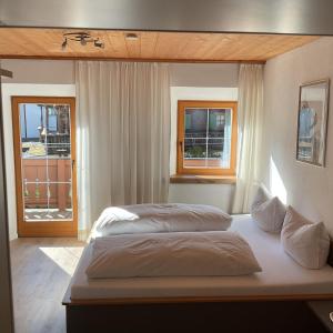 1 dormitorio con 2 camas y ventana en Landgasthof Dorfstadl, en Kössen