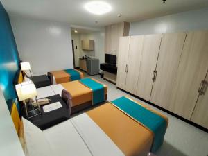 a room with two beds and cabinets in a room at Studio 89 Katipunan QC in Manila