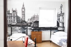 a bedroom with two beds with a picture of big ben at Leo Hostel in Poznań