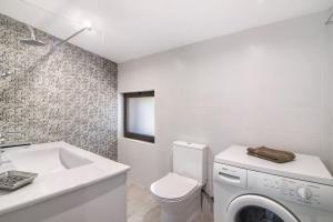 een badkamer met een toilet, een wastafel en een wasmachine bij Fontenoy in Tavira