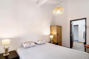 een slaapkamer met een groot wit bed met 2 kussens bij Fontenoy in Tavira