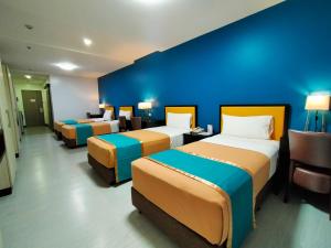 Habitación con 3 camas y pared azul. en Studio 89 Katipunan QC en Manila