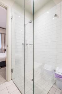 a bathroom with a glass shower with a toilet at Collins Street Luxury 2 BR Apartment in Melbourne