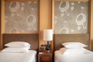 曼谷的住宿－曼谷易思廷大酒店沙吞，酒店的客房内设有两张带白色枕头的床。