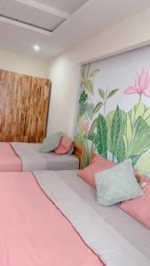 two beds in a room with a mural on the wall at Ehome Saigon - Gạo hostel in Ho Chi Minh City