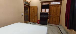 a room with a refrigerator and some wooden doors at Hotel O HOME Swagat Homestay in Ayodhya