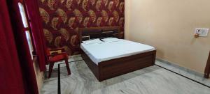 a small bed in a room with a red curtain at Hotel O HOME Swagat Homestay in Ayodhya