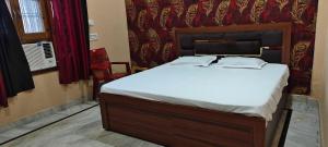 a bedroom with a large bed with white sheets at Hotel O HOME Swagat Homestay in Ayodhya