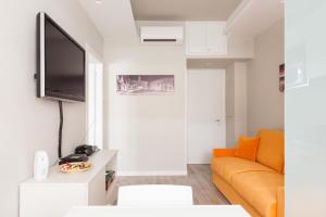 een woonkamer met een bank en een flatscreen-tv bij Un Passino da San Pietro Casa in Rome