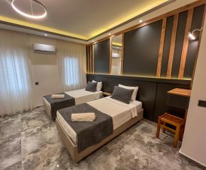 a hotel room with two beds and a mirror at Rain Hotel in Kizkalesi