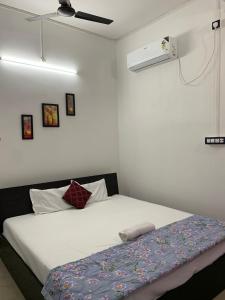 una camera con un letto bianco e un soffitto bianco di JP Hotel a Tezpur