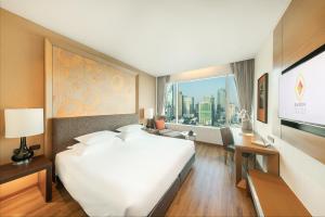 a hotel room with a large white bed and a window at Eastin Grand Hotel Sathorn in Bangkok