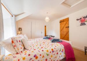 a bedroom with a bed with a floral bedspread at Shillingstones in Saint Teath