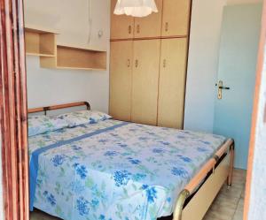 a bedroom with a bed with a blue and white comforter at Conero 33 Primo Piano Casa Vacanze in Numana