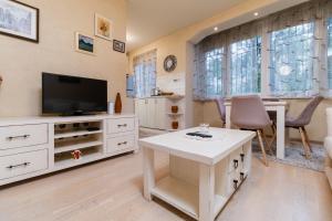 a living room with a tv and a table at Elegant 1-Bedroom Apartment in Plovdiv