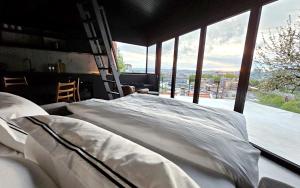 Edge Oslo - Hideaway with Breathtaking City Views في أوسلو: سرير في غرفة مع نافذة كبيرة