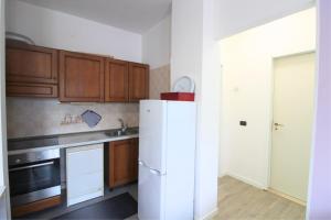 a kitchen with a white refrigerator and wooden cabinets at Holiday in Caorle