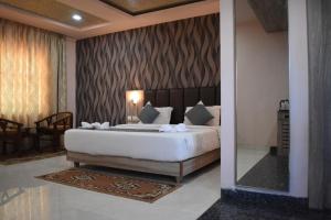a bedroom with a large bed and a mirror at Hotel Vip Square in Puri