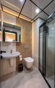 W łazience znajduje się toaleta, umywalka i prysznic. w obiekcie Rain Hotel w mieście Kizkalesi