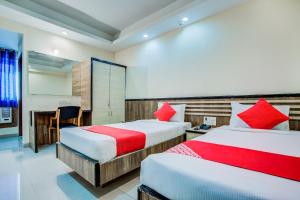 een hotelkamer met 2 bedden met rode kussens bij OYO 7239 Hotel Aditya in Rānchī