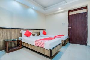een slaapkamer met 2 bedden en rode kussens bij OYO 7239 Hotel Aditya in Rānchī