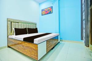 1 dormitorio con 1 cama con cabecero de madera en OYO Sirsa Hotel & Guest House en Sirsa